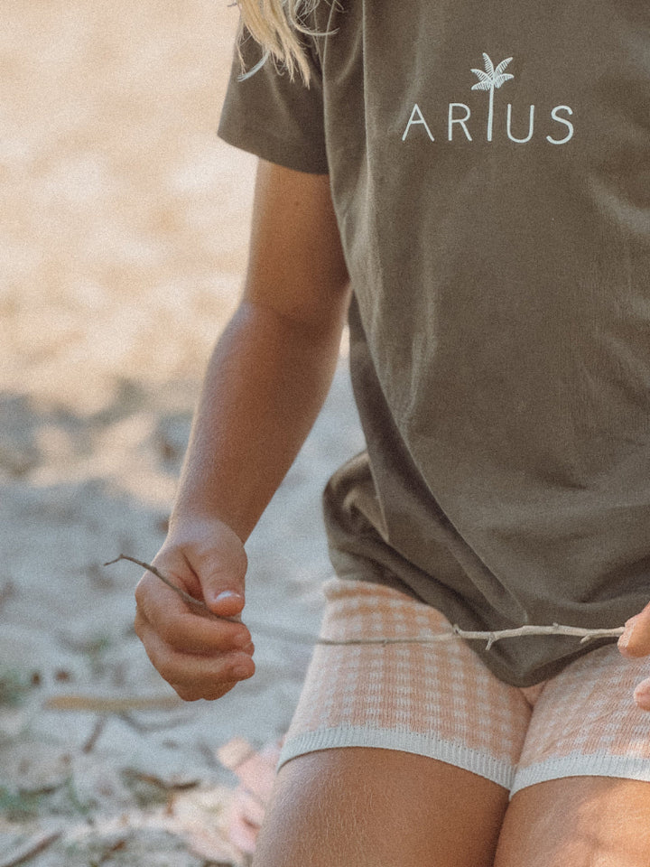 Khaki green organic cotton kids t-shirt on beach in Australia