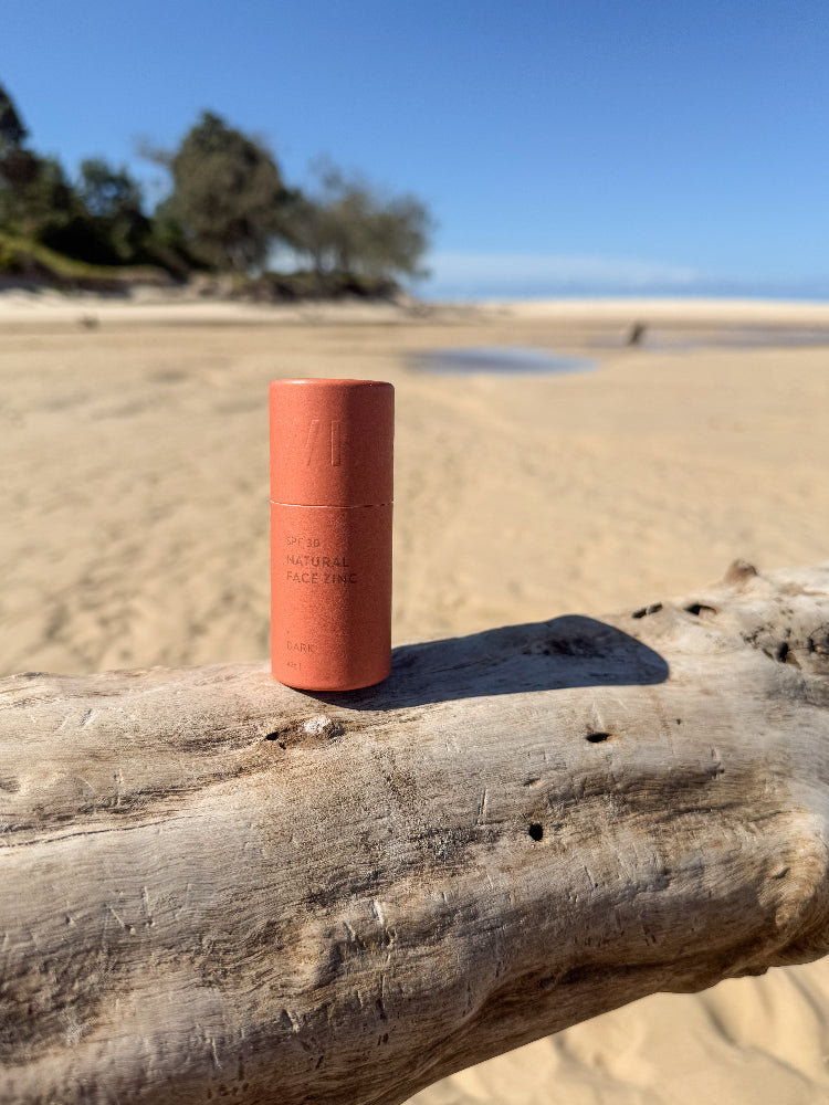 Winki Zinc SPF 30 natural face zinc dark shade on driftwood at beach