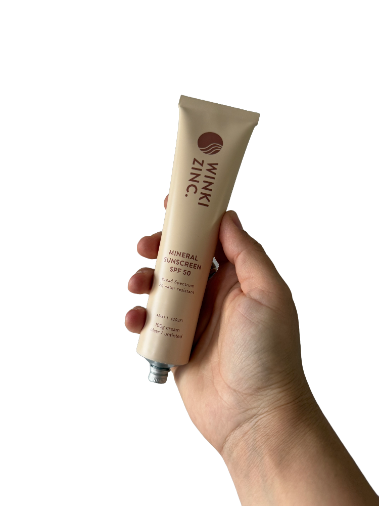 Winki Zinc SPF 50 mineral sunscreen tube held up in hand. 